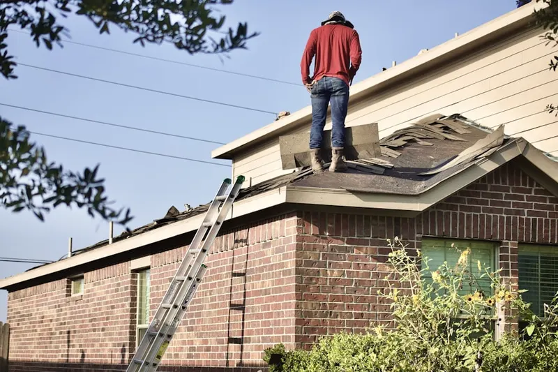 Professional roofer working on a residential roof in Kleinman Park